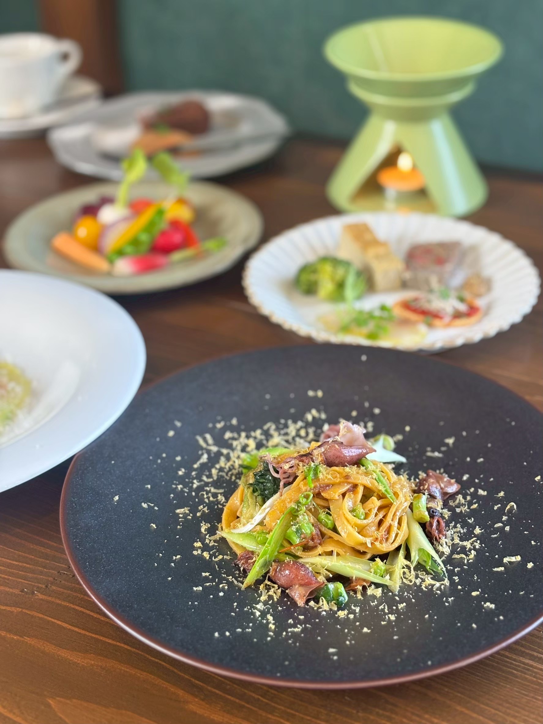 cucina cazのパスタ。奥には前菜や野菜の一皿
